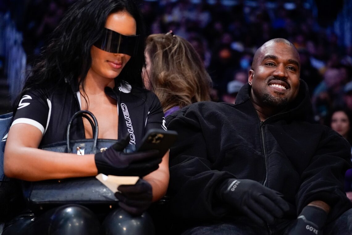 Kanye West salutes the crowd as he takes his Kim Kardashian clone girlfriend Chaney Jones to watch the LA Lakers